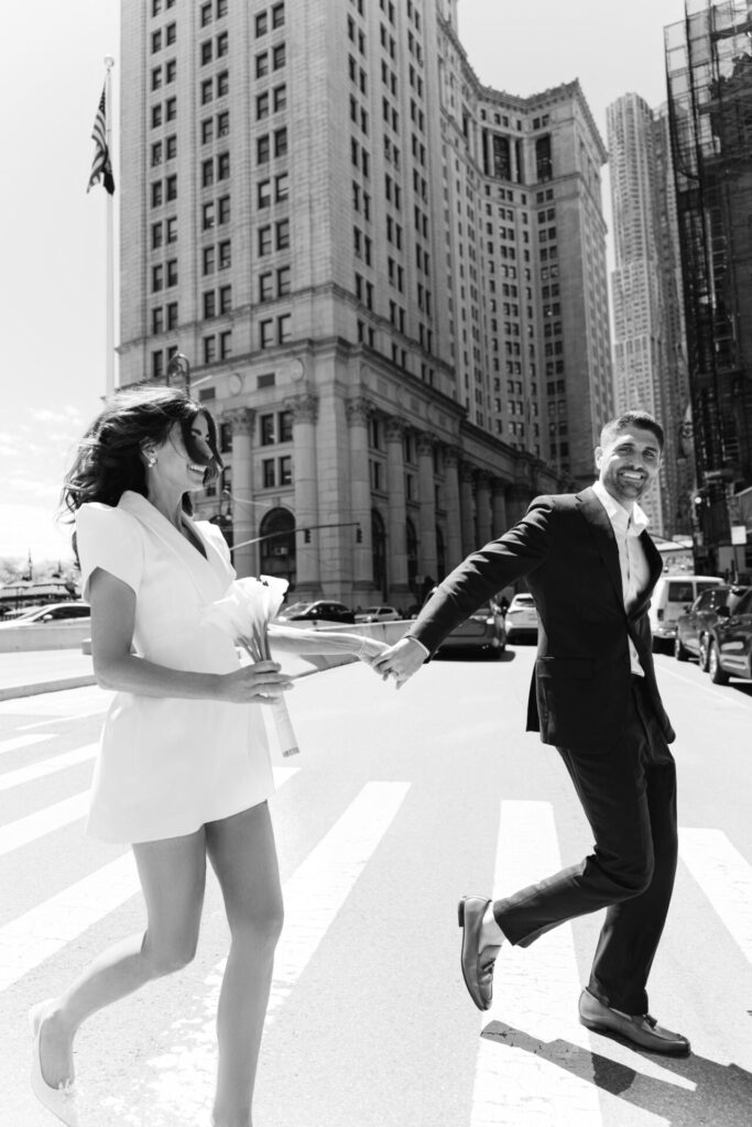 Couple crossing a street in Lower Manhattan during a New York City elopement photoshoot.